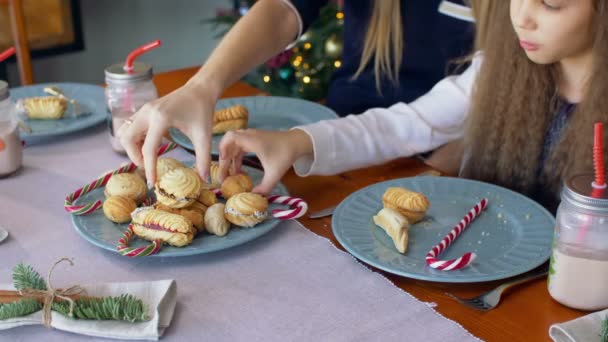 Руки, берущие рождественское печенье и конфеты с тарелки — стоковое видео