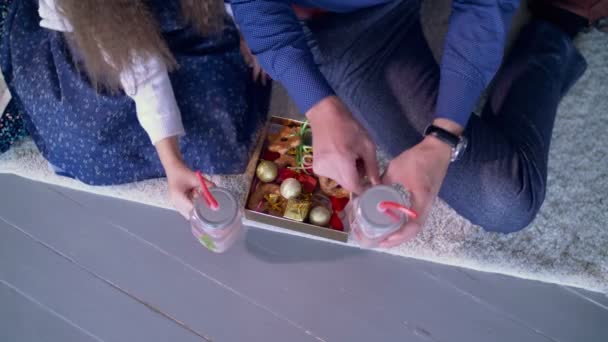 Manos humanas sosteniendo la bebida de Navidad y el pan de jengibre — Vídeos de Stock