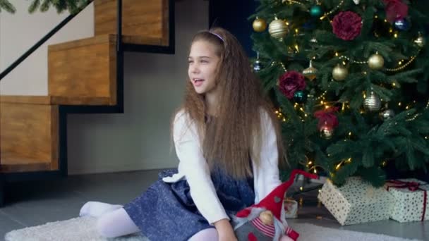 Niña buscando regalos bajo el árbol de Navidad — Vídeos de Stock