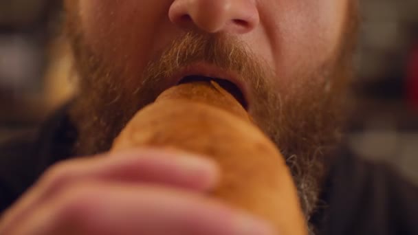 Szakállas ember eszik croissant portréja — Stock videók