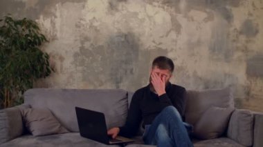 Gece geç saatlerde dizüstü bilgisayarda çalışan işkolik adam