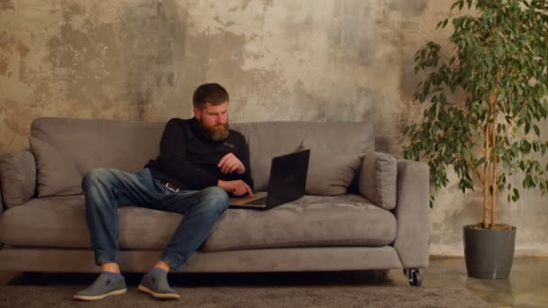 Фрилансер, работающий онлайн с ноутбуком на дому — стоковое видео