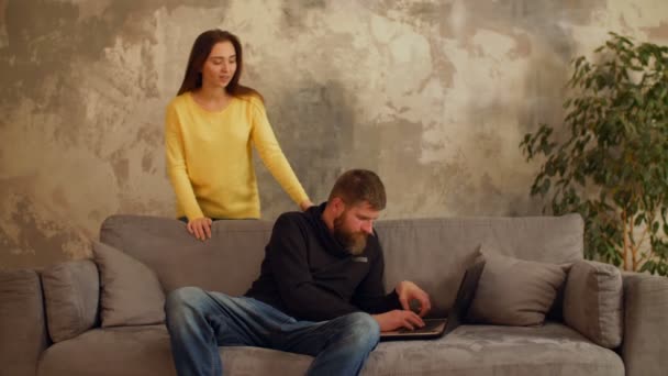 Чоловік зайнятий робочим ноутбуком, поки дівчина почувається самотньою — стокове відео