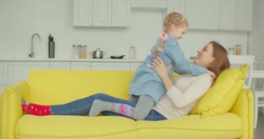 Kaygısız anne ve kızı koltukta eğleniyor