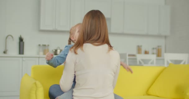 Sonriendo alegre niña abrazando a la madre felizmente — Vídeos de Stock