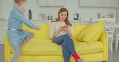 Neşeli küçük kız onu meşgul annemin yardıma ihtiyacı