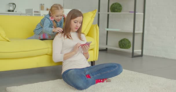 Sevimli kız ve anne ile akıllı telefon online tarama — Stok video