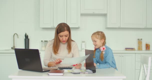 Madre positiva calculando facturas con hija — Vídeo de stock