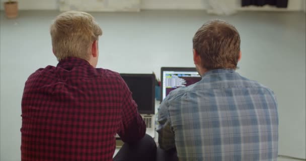 Programadores escribiendo códigos fuente en la oficina creativa — Vídeo de stock