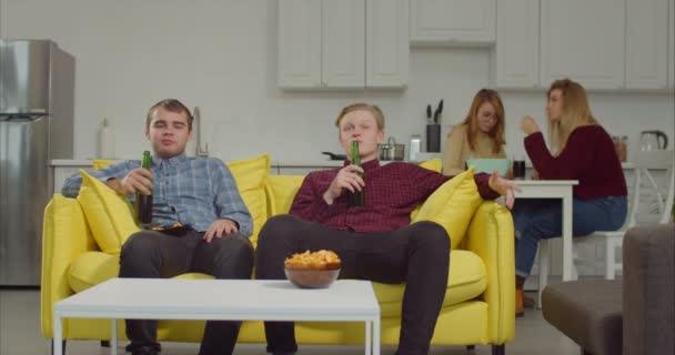 Friends watching soccer on tv with beer and snacks — Stock Video