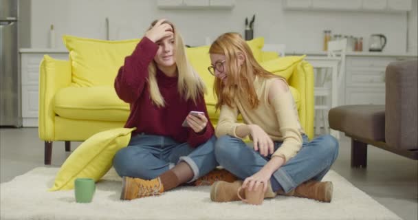 Fröhliche Freundinnen teilen Smartphone zu Hause — Stockvideo