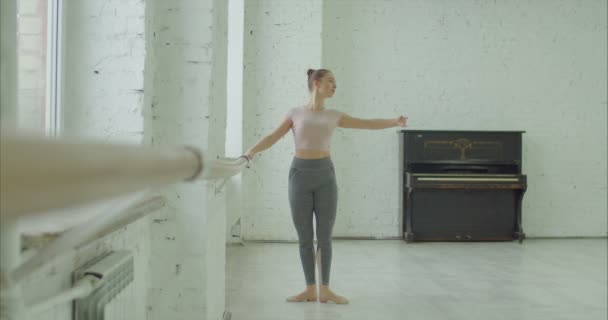 Balletdanseres doen battement tendu oefening op barre — Stockvideo