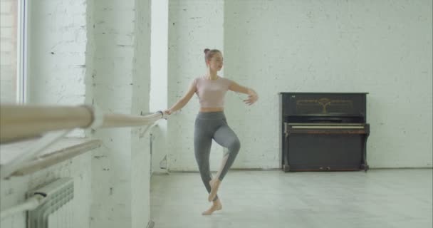 Balletdanseres uitvoeren petit oefening bij barre — Stockvideo