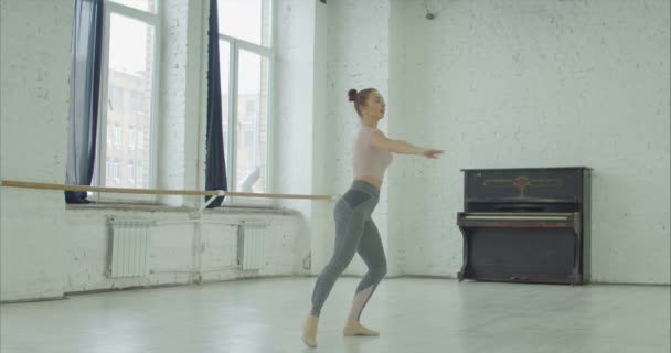 Ballerina practicing fouette turn in dance studio — Stock Video