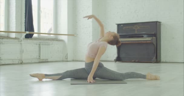 Fit kadın sağ bacak ileri ile ön bölünmüş yapıyor — Stok video