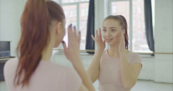 Mujer encantadora regocijando su reflejo en el espejo — Vídeos de Stock