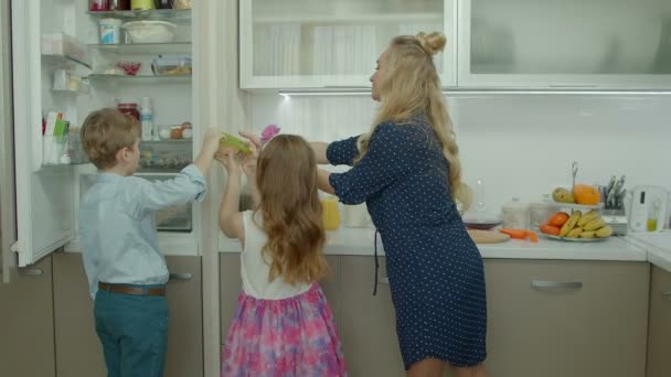 Schattige kinderen helpen moeder te maken ontbijt thuis — Stockvideo
