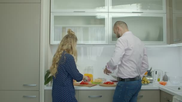 Χαρούμενη περιστασιακή ζευγάρι προετοιμασία φαγητού στην κουζίνα — Αρχείο Βίντεο