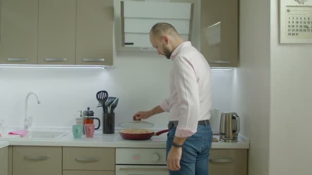 Одинокий мужчина готовит омлет на завтрак на кухне — стоковое видео