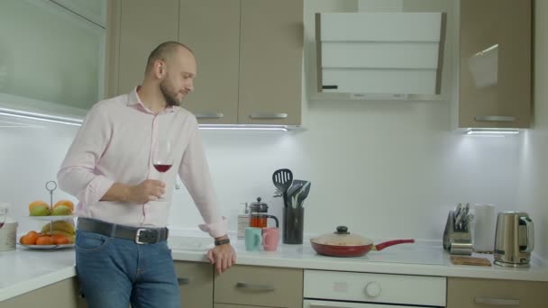 Positivo Uomo Barbuto Casuale Sorseggiando Vino Rosso Mentre Cucina Cucina — Video Stock