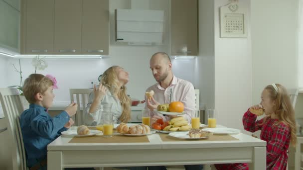 Familie thuis eten ontbijt in keuken samen — Stockvideo