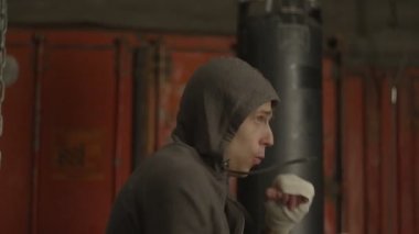 Kararlı kickboks adam eğitim salonunda yumruk atıyor.