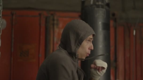 Determinado kickboxing hombre entrenamiento golpes en el gimnasio — Vídeos de Stock