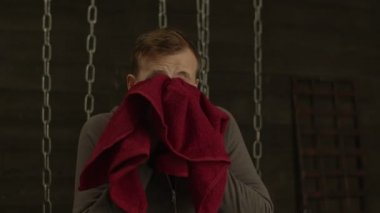 Fiziksel olarak yorgun sportif adam ter havlu ile silinerek