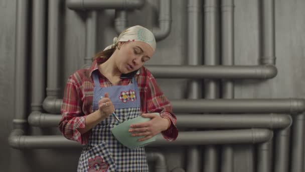 Multitasking vrouw praten over de telefoon tijdens het koken — Stockvideo