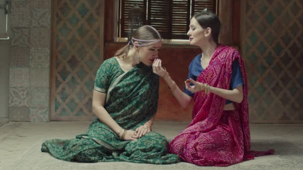 Admiradas hembras en sari oliendo sachet fragante — Vídeos de Stock