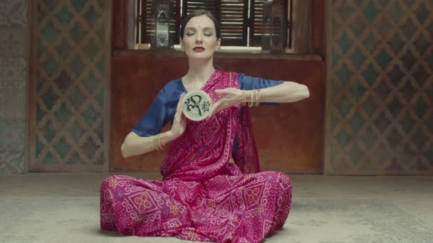 Очаровательная женщина играет медитативную индийскую музыку — стоковое видео