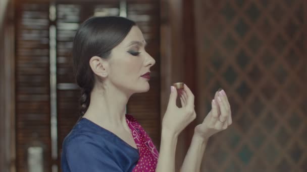 Жінка в сарі нюхає смачний саше аромату — стокове відео