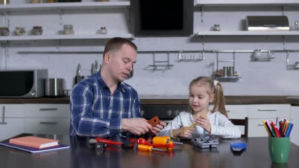 Papá mostrando en acción a la niña el uso de la llave inglesa — Vídeo de stock