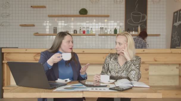 Empresarias tomando café hablando en la cafetería — Vídeo de stock