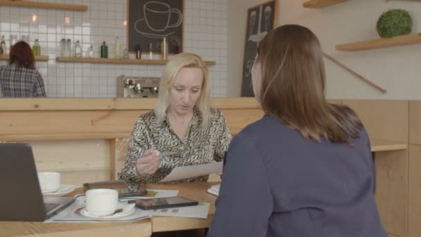 Femme d'affaires lisant la police d'assurance dans le café — Video