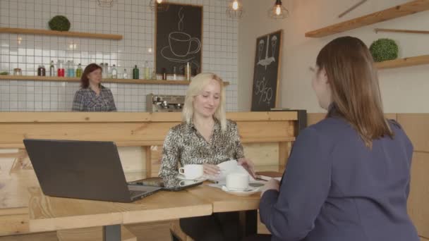 Деловые женщины рукопожатия заключают сделку в кафе — стоковое видео