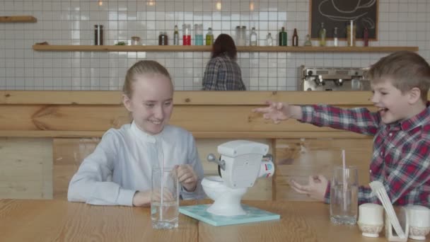 Niños felices riendo jugando juguete en la mesa de la cafetería — Vídeo de stock