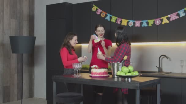 Lyckliga kvinnor sätta på partyhattar hemma födelsedag — Stockvideo