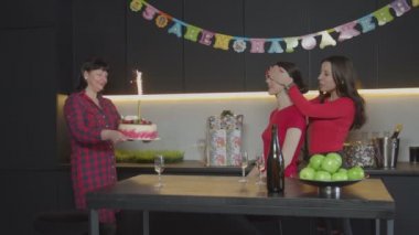 Doğum günü partisinde ışıltılı pasta getiren anne