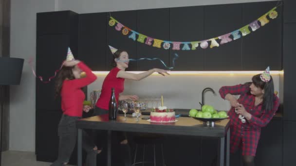 Mulheres felizes jogando serpentina na festa de aniversário — Vídeo de Stock