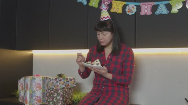 Vrouw eet verjaardagstaart alleen in huis keuken — Stockvideo