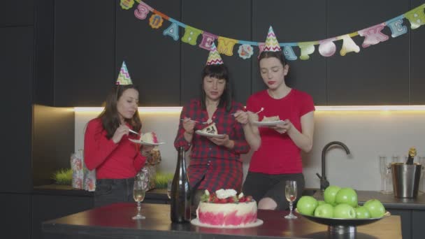 Gelukkige vrouwen eten verjaardagstaart in huis keuken — Stockvideo
