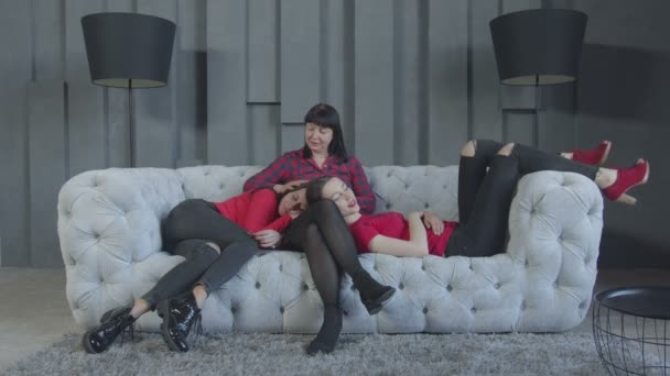 Anya simogató felnőtt lányai pihentető kanapé — Stock videók
