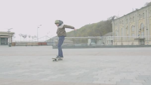 Tiener Skater beoefenen shuvit truc in stadsplein — Stockvideo