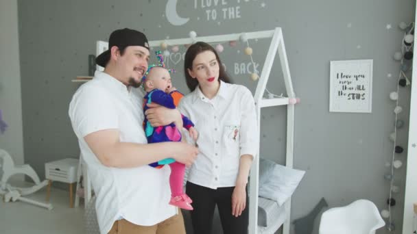 Gelukkige familie met baby uitziend raam thuis — Stockvideo