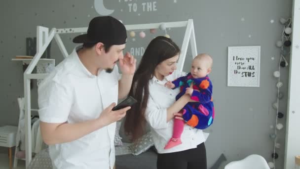 Jovem mãe balançando menina infantil a mãos em casa — Vídeo de Stock