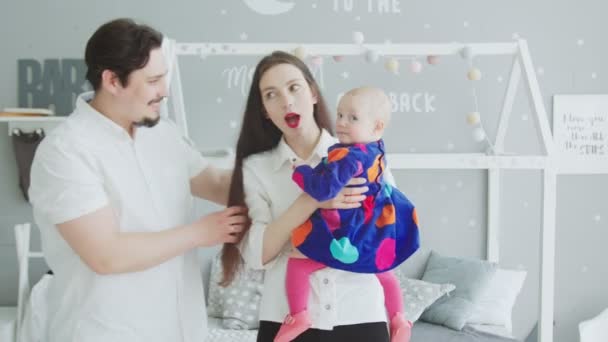Fröhliche Eltern, die mit ihrem Baby zu Hause kommunizieren — Stockvideo