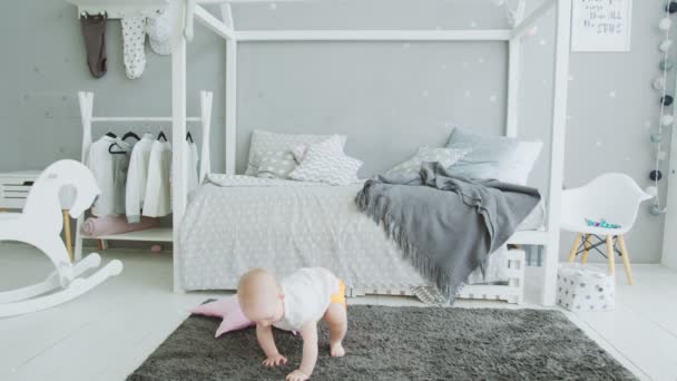 Cute baby trying to get up from floor at home — Stock Video