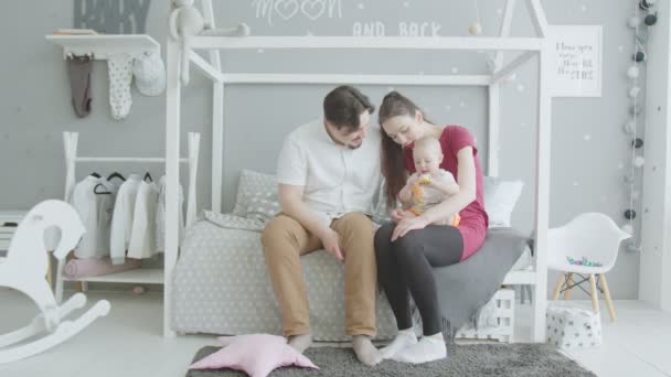 Joyful parents playing with baby girl in bedroom — Stock Video