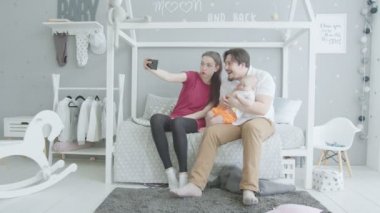 Evde ortak selfie çeken bebek ile mutlu aile